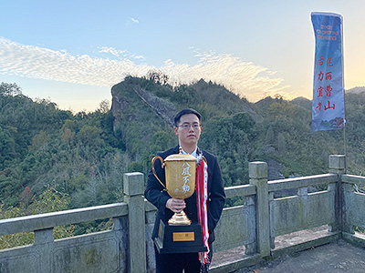 図3：「八風不動」と刻まれた優勝トロフィーを手にする陳梓健八段。