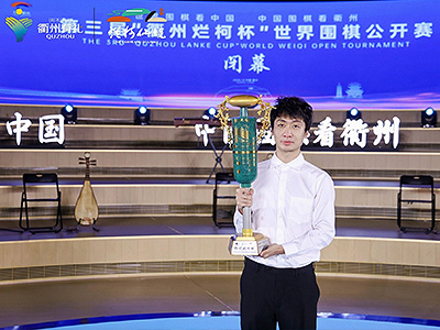 図2：党毅飛九段がトロフィーを掲げる。